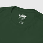 Man with a beard wearing a forest green Moto Culture Heavyweight T-Shirt featuring gold 'Horizon' script on the chest, styled with blue jeans.