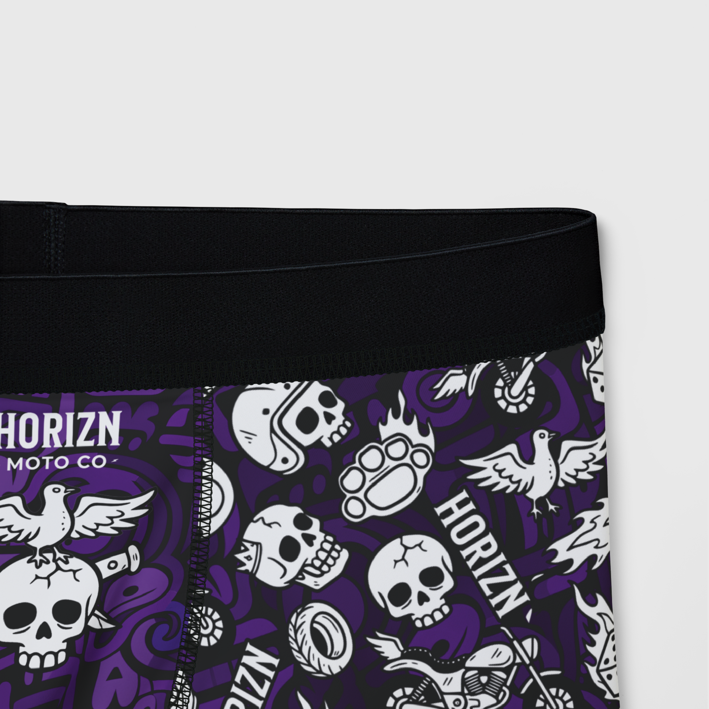 Men's purple moto skull boxer briefs featuring all-over graphic design of skulls, flames, and helmets. Perfect for riders seeking comfort and style.