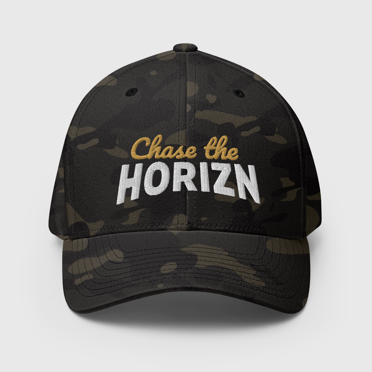 Front view of the Multicam Black camouflage Chase the HORIZN Flexfit cap, with gold-and-white embroidered lettering and a curved visor.