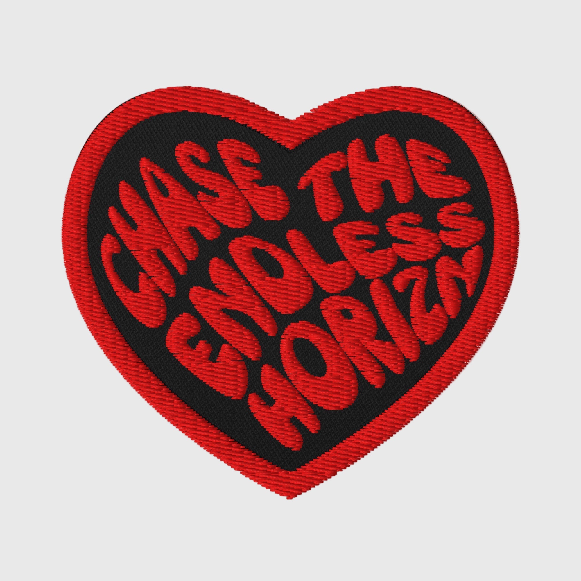 Red heart-shaped embroidered patch with the phrase 'Chase the Endless Horizn' on a black background, featuring durable twill fabric for lasting wear. Perfect for personalizing jackets and bags.