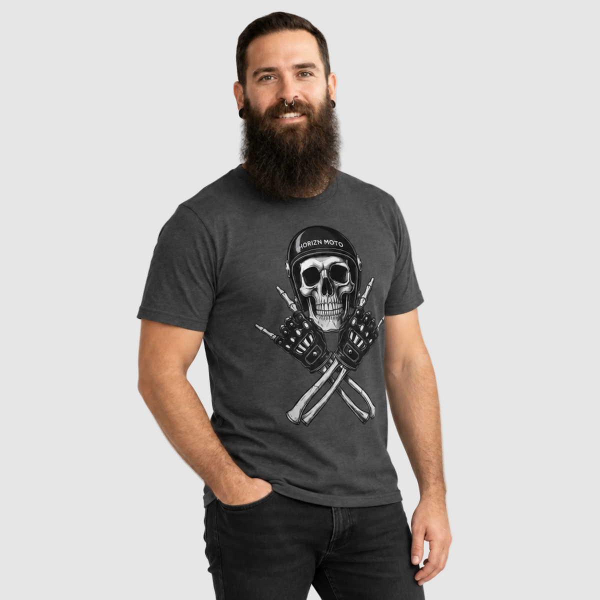 Model wearing the charcoal Rebel Bones Moto Tee with skull helmet and crossed biker gloves artwork.